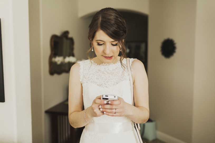 photo journalism of bride texting during her wedding at UC Davis by Heather Elizabeth Photography
