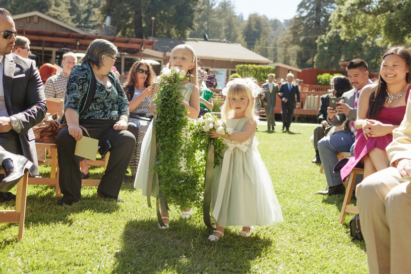 Flower girls bringing green heavy florals down the aisle together during an eco friendly organic wedding at the mountain terrace by heather elizabeth photography