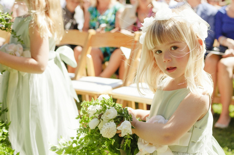 Flower girl with white rose flower crown walking to the aisle at a same sex wedding in woodside california by heather elizabeth photography