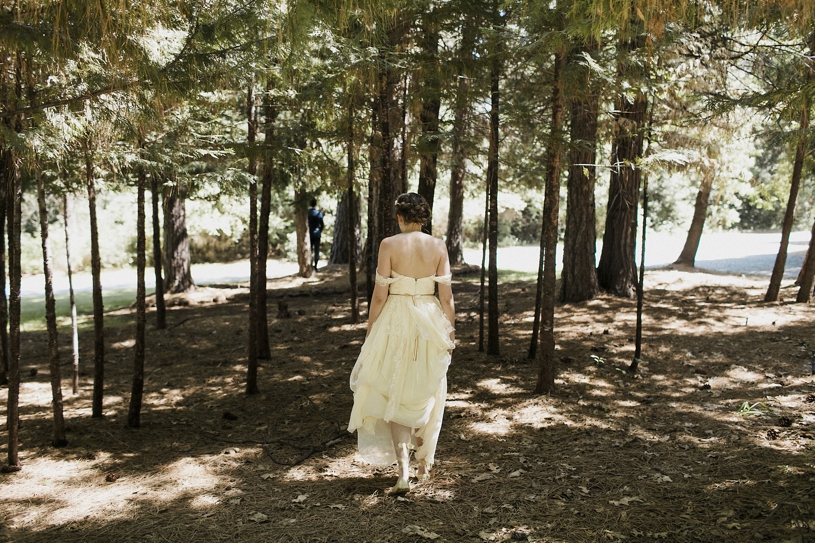 Bride walking to her first look wearing her Sarah Seven dress at the Forest House Lodge by Heather Elizabeth Photography